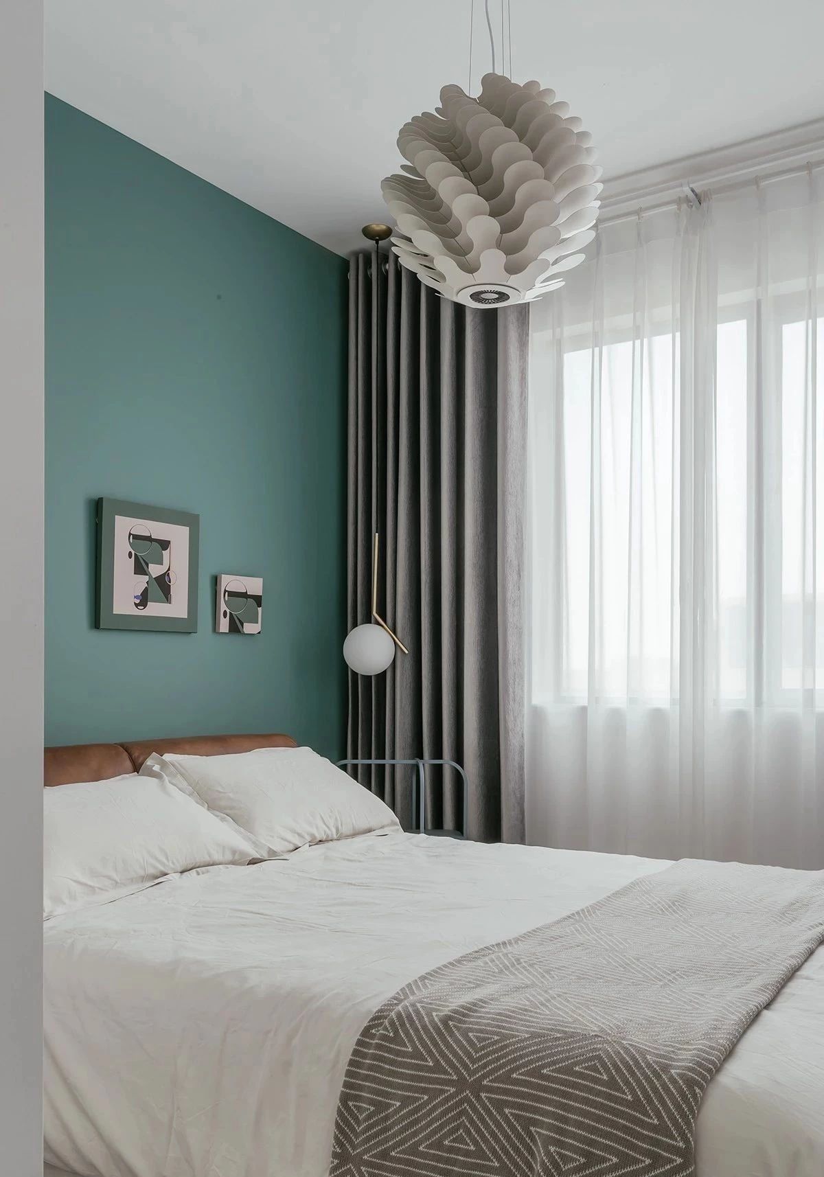 以海洋綠作為次臥床頭背景墻主色調，配上灰色窗簾，優雅靜謐